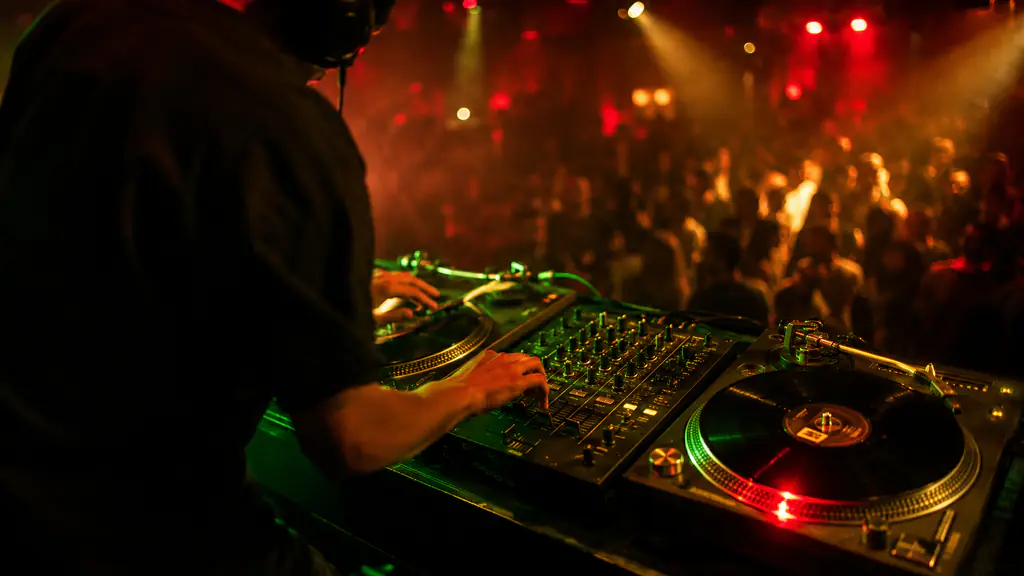 Deejay Tin'Ok a mixar em pratos de vinil - set diante de uma pista cheia